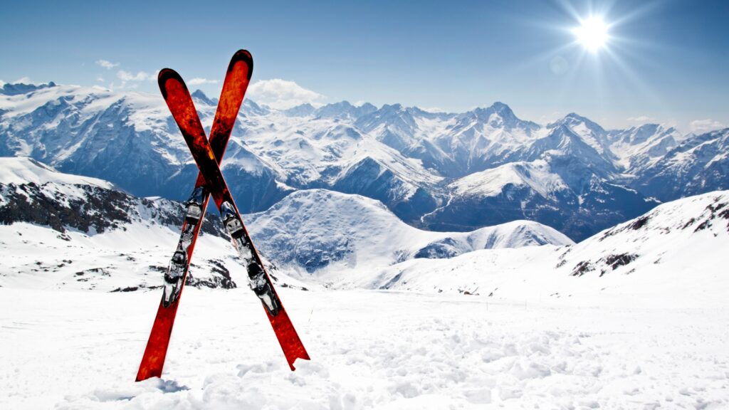 pair of red skis crossed and wedged in snow on mountain picture id149396055